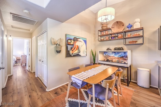 dining space featuring a textured ceiling and light hardwood / wood-style flooring