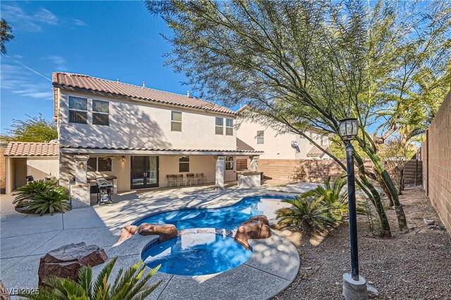 view of swimming pool featuring a bar, an outdoor kitchen, an in ground hot tub, and a patio area