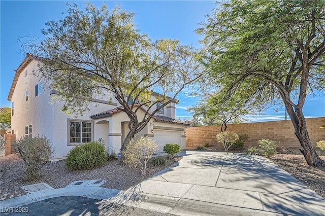 view of front facade featuring driveway, a tile roof, fence, and stucco siding