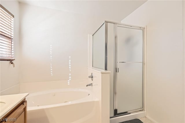 bathroom featuring a shower stall, a bath, and vanity