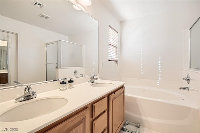 bathroom with a bath, visible vents, and a sink