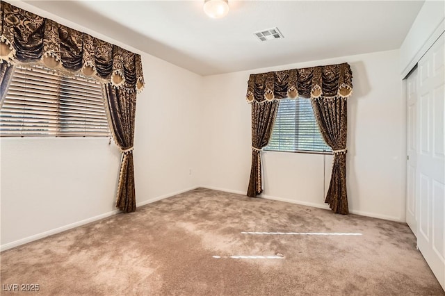 unfurnished bedroom featuring a closet, visible vents, baseboards, and carpet flooring