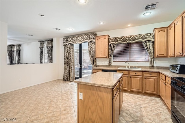 11276 Accademia Ct, Las Vegas, NV 89141 - kitchen with a sink, black gas stove, a kitchen island, light stone counters, and recessed lighting