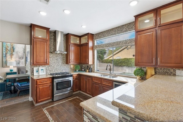 kitchen with stainless steel range with electric cooktop, sink, wall chimney exhaust hood, light stone countertops, and tasteful backsplash