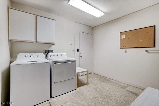 laundry room with a textured ceiling, cabinets, independent washer and dryer, and light carpet