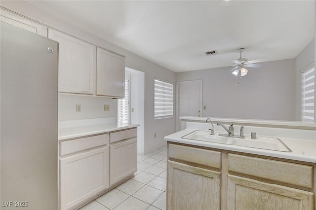 kitchen with light tile patterned flooring, ceiling fan, a wealth of natural light, and sink