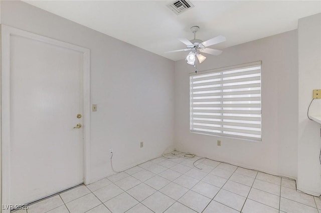 tiled spare room featuring ceiling fan