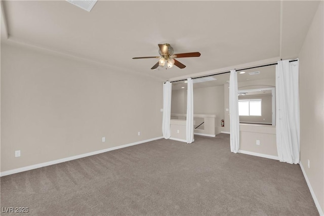 unfurnished bedroom with a barn door, ceiling fan, and carpet flooring