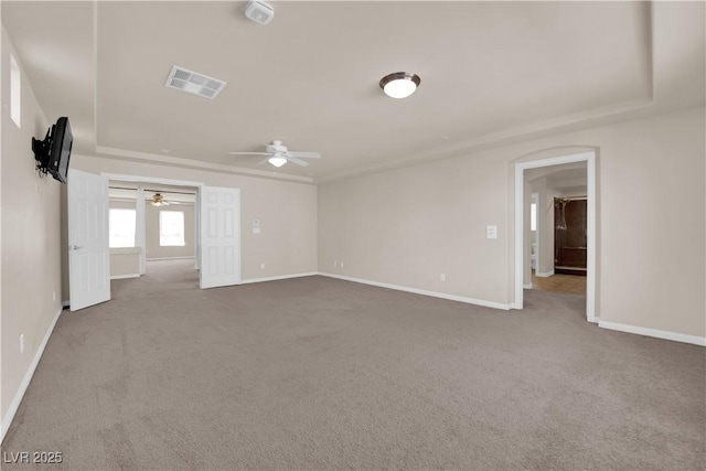 empty room featuring ceiling fan, a tray ceiling, and carpet