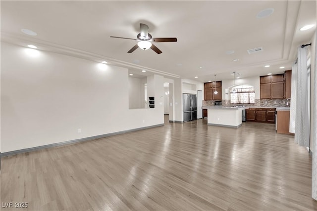 unfurnished living room with ceiling fan and light hardwood / wood-style floors