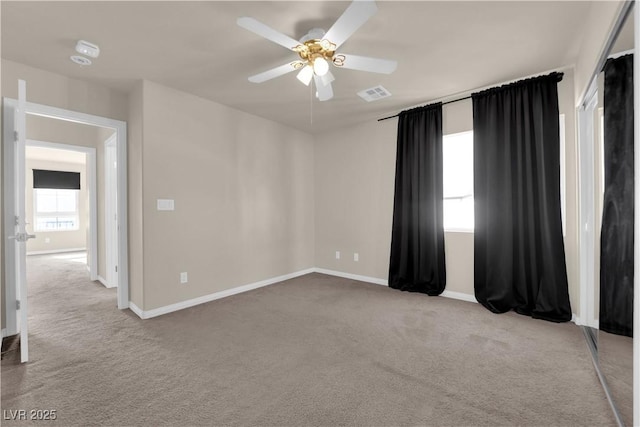 carpeted spare room featuring ceiling fan