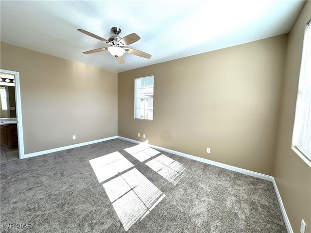 spare room with dark colored carpet and ceiling fan