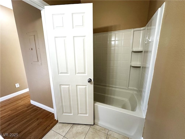 bathroom featuring bathing tub / shower combination, electric panel, and tile patterned flooring