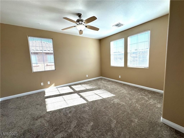 empty room with a textured ceiling, carpet floors, and ceiling fan