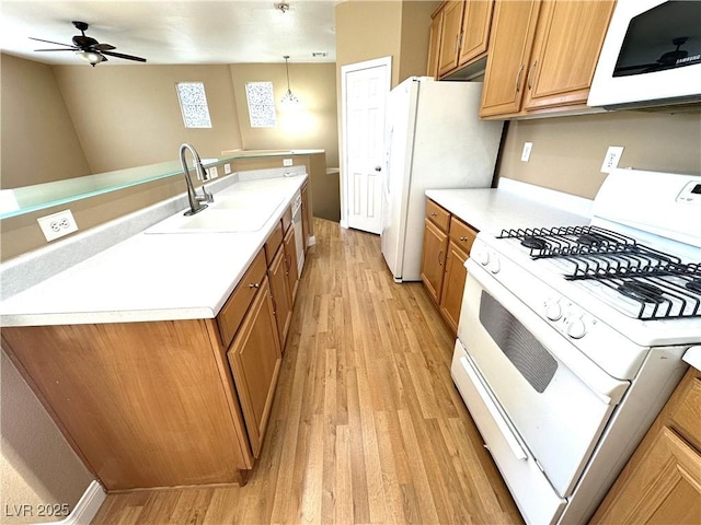 kitchen featuring white appliances, sink, decorative light fixtures, light wood-type flooring, and ceiling fan