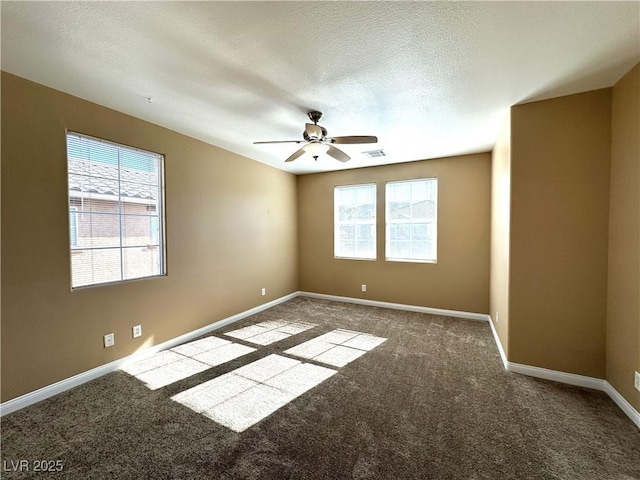 carpeted spare room featuring ceiling fan and a textured ceiling