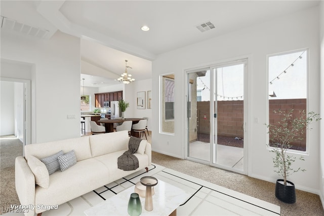 living room with carpet, lofted ceiling, and a chandelier