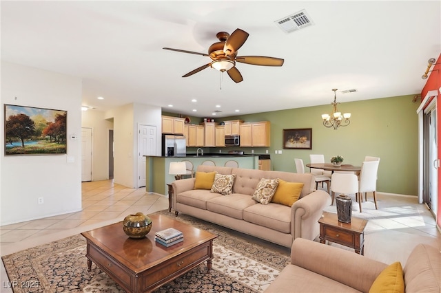 living room with ceiling fan with notable chandelier, light tile patterned floors, and sink