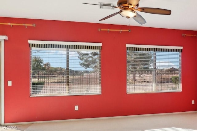 empty room with ceiling fan and a healthy amount of sunlight