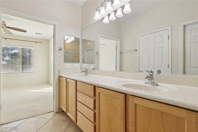 bathroom featuring tile patterned floors, vanity, and ceiling fan with notable chandelier