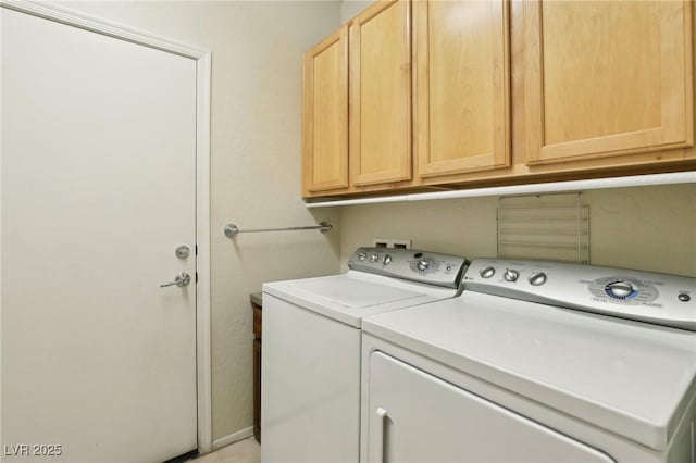 washroom with washer and clothes dryer and cabinets