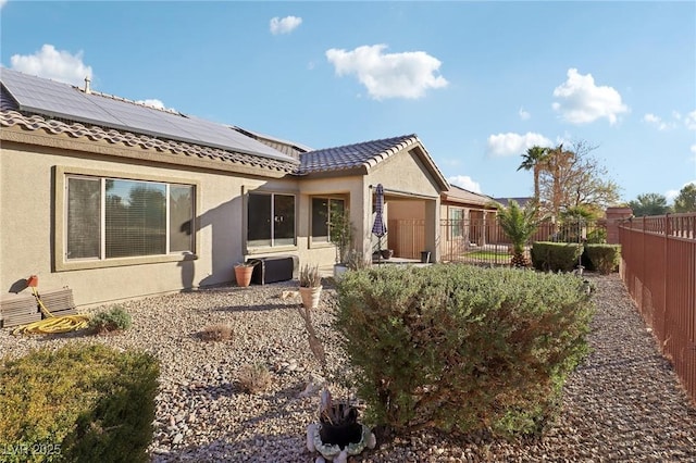 back of house featuring solar panels