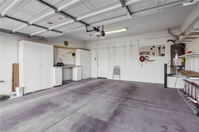 garage featuring strapped water heater and a garage door opener