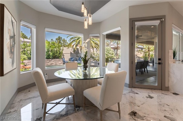 dining room featuring a chandelier, marble finish floor, and baseboards