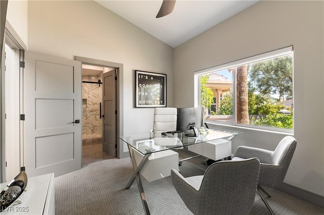 home office featuring baseboards, ceiling fan, carpet floors, and high vaulted ceiling
