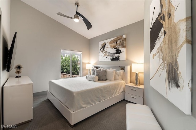 bedroom featuring vaulted ceiling, dark colored carpet, and a ceiling fan