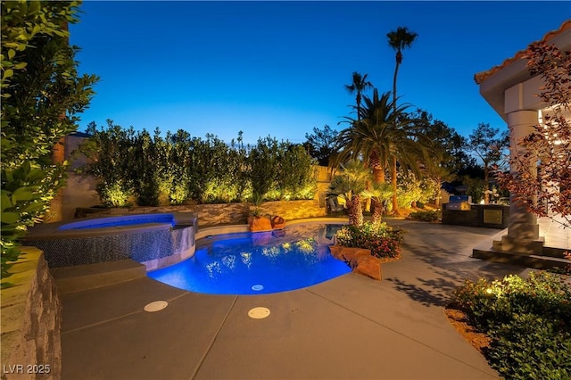 outdoor pool with a patio and an in ground hot tub