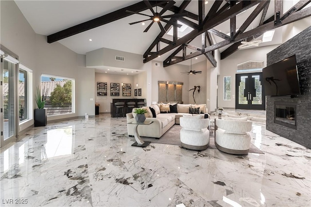 living room featuring visible vents, a glass covered fireplace, ceiling fan, beamed ceiling, and marble finish floor