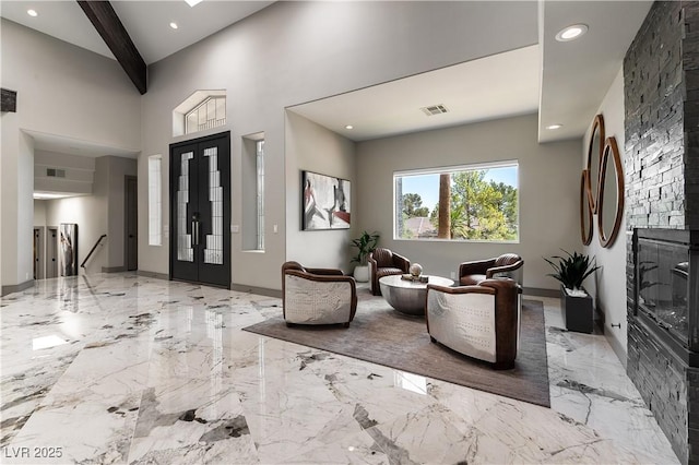 foyer entrance with marble finish floor, french doors, recessed lighting, visible vents, and a glass covered fireplace