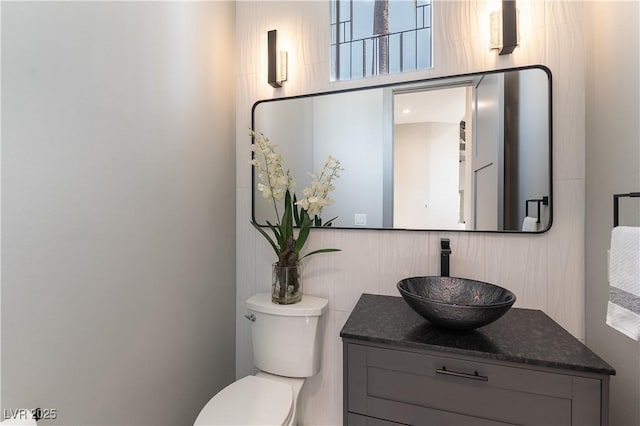 half bath featuring vanity and toilet