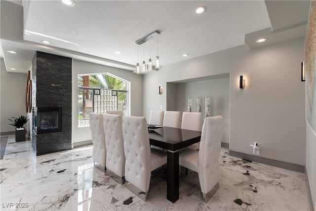 dining space with recessed lighting, marble finish floor, a stone fireplace, and baseboards