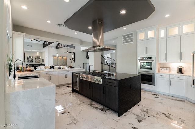 kitchen featuring a sink, stainless steel appliances, island exhaust hood, and visible vents