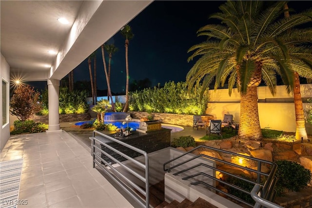 patio at night featuring a fire pit