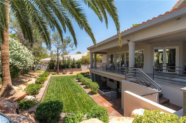 view of yard with french doors and fence