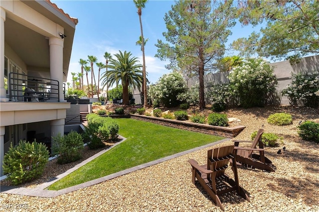 view of yard featuring fence and a balcony