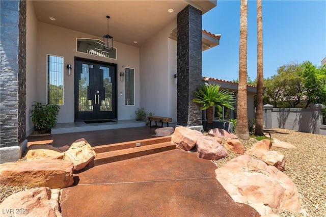 property entrance featuring stucco siding and french doors