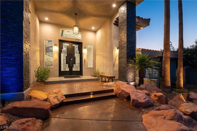 property entrance with stucco siding and french doors