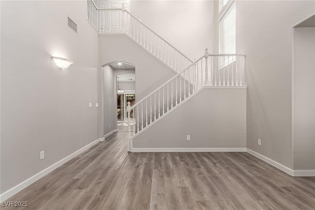 interior space with wood-type flooring and a towering ceiling