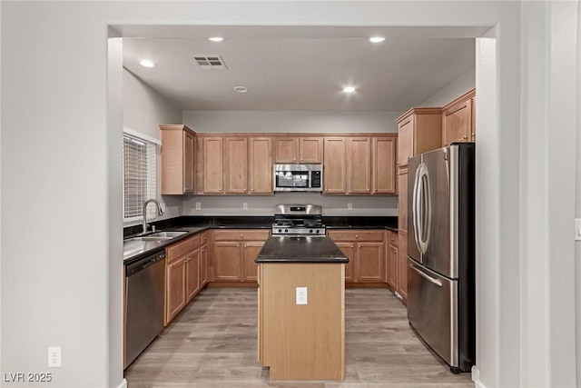 kitchen featuring a center island, light wood-type flooring, sink, and appliances with stainless steel finishes