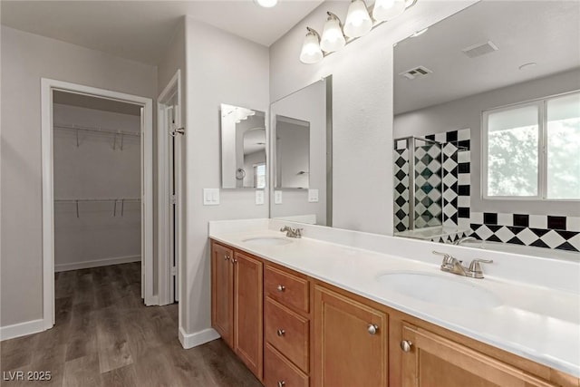 bathroom with hardwood / wood-style flooring, vanity, and walk in shower