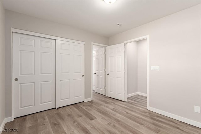 unfurnished bedroom with light hardwood / wood-style floors and a closet