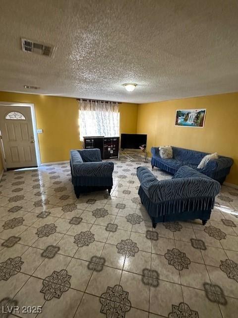 living room with tile patterned flooring and a textured ceiling