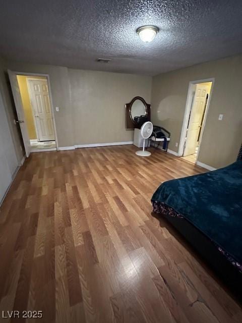 unfurnished bedroom featuring wood-type flooring and a textured ceiling