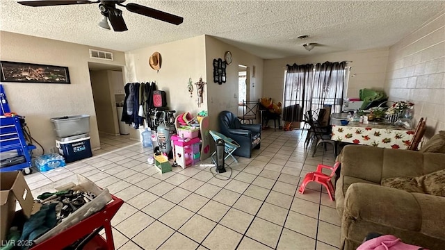 tiled living room featuring ceiling fan and a textured ceiling