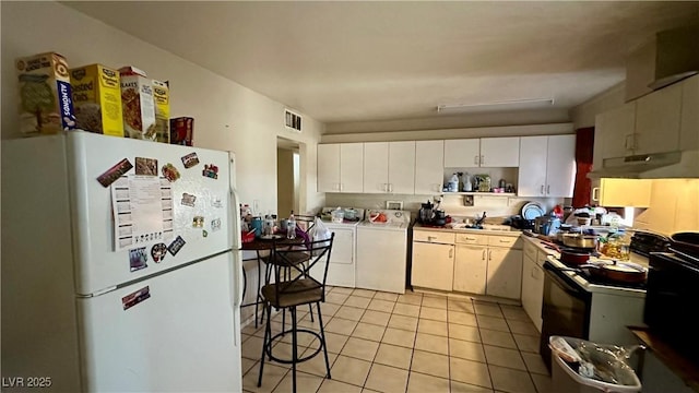 kitchen featuring washer and dryer, light tile patterned floors, black range with electric cooktop, white fridge, and white cabinets