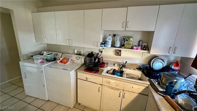 laundry room featuring light tile patterned floors, sink, and independent washer and dryer